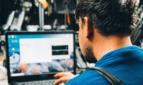 Technik przy laptopie z oprogramowaniem diagnostycznym w warsztacie