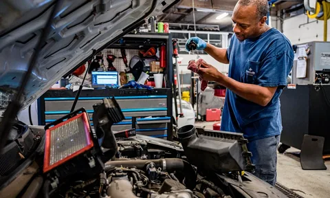 Mechanik przy otwartej komorze silnika z testerem diagnostycznym